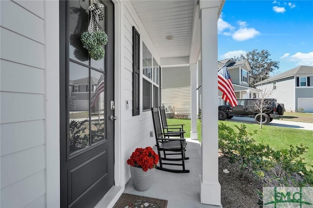 property entrance with a residential view, covered porch, and a lawn