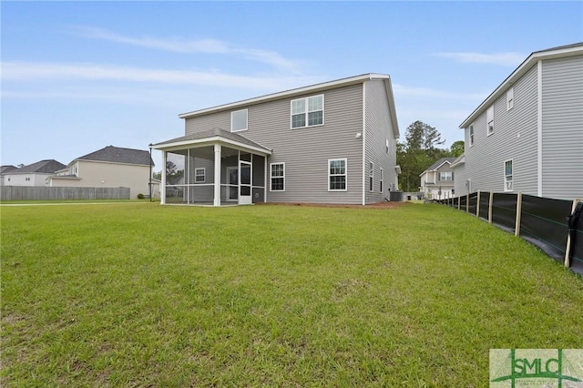 back of house with fence, a yard, and a sunroom