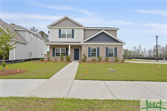 view of front of house featuring brick siding, a front lawn, and covered porch