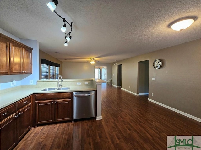 kitchen with stainless steel dishwasher, a peninsula, dark wood-style flooring, light countertops, and a sink