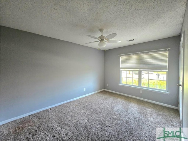 carpeted empty room featuring a textured ceiling, ceiling fan, baseboards, and visible vents