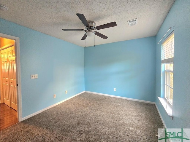 spare room with visible vents, baseboards, a ceiling fan, a textured ceiling, and carpet floors