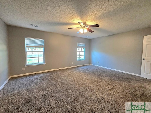 unfurnished room featuring carpet, a textured ceiling, a ceiling fan, visible vents, and baseboards