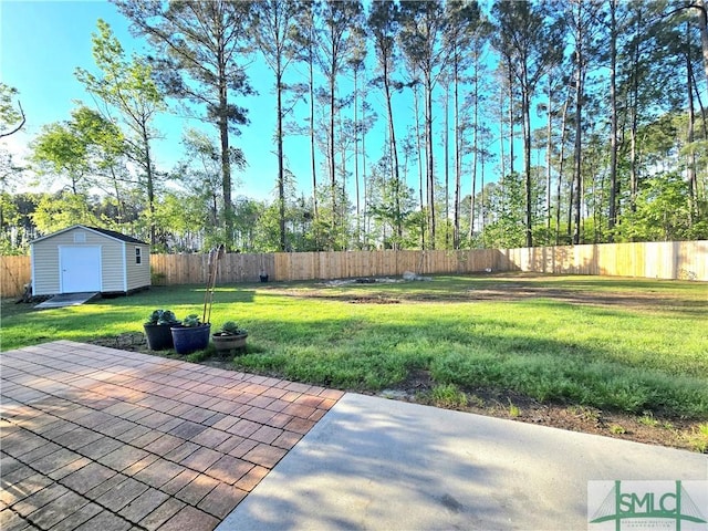 view of yard with a patio, a fenced backyard, an outdoor structure, and a storage unit