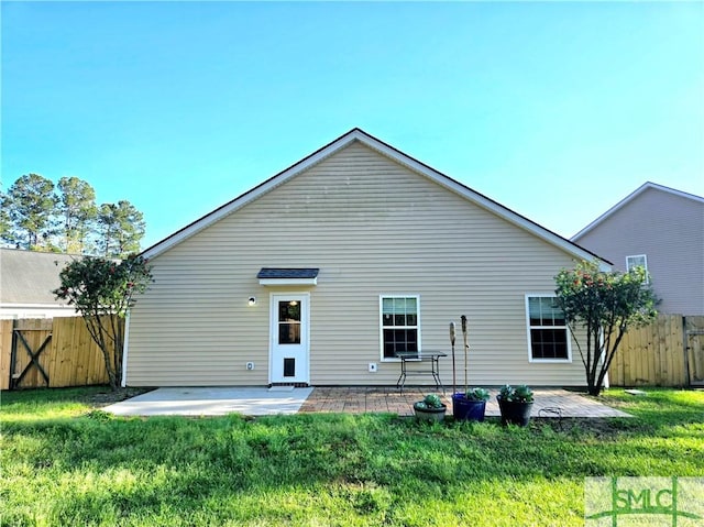 rear view of house featuring a patio area, a yard, and fence