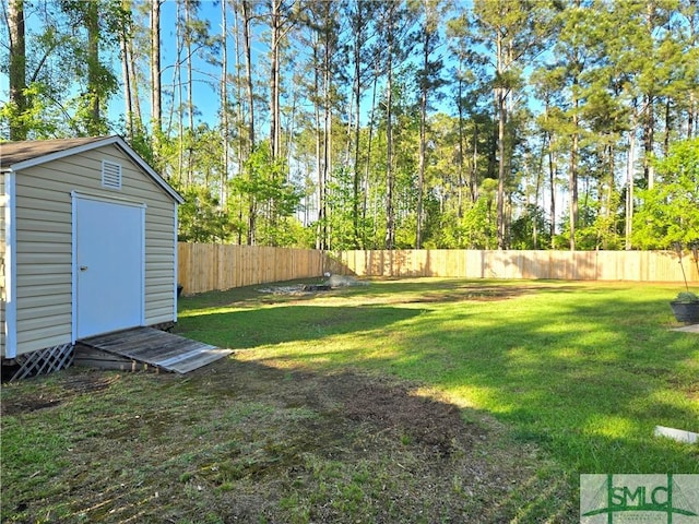 view of yard with an outbuilding, a storage unit, and a fenced backyard