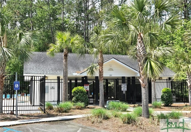 view of front facade featuring roof with shingles and a fenced front yard