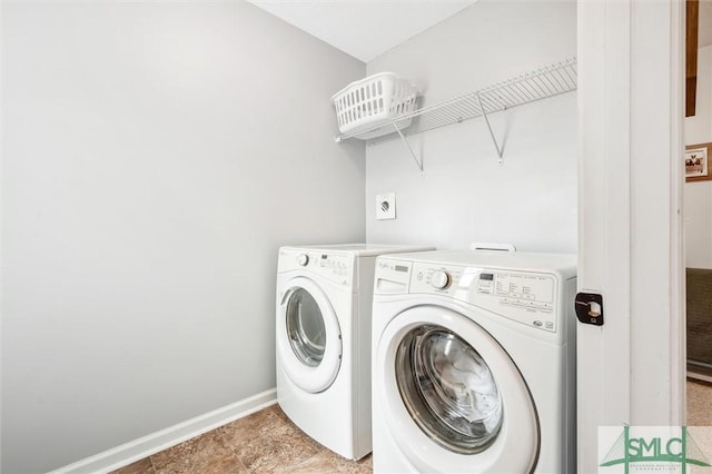 laundry area featuring baseboards, separate washer and dryer, and laundry area