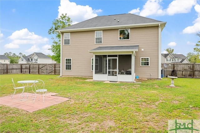 rear view of property with a sunroom, a patio area, a fenced backyard, and a lawn