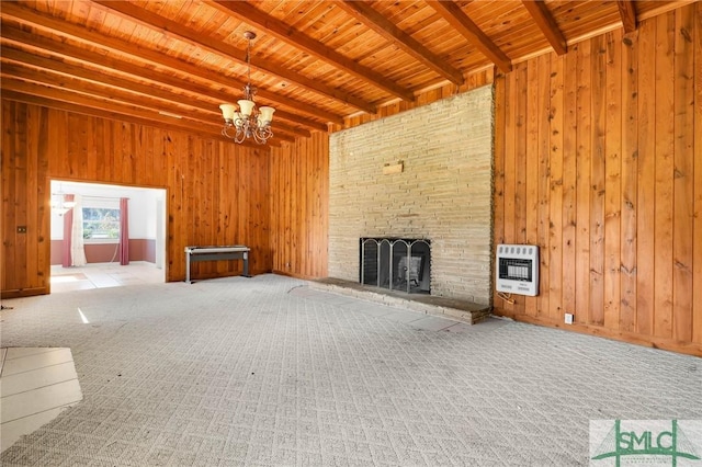 1505 Wilson Rd, Brooklet, GA 30415 - unfurnished living room featuring an inviting chandelier, wood walls, beam ceiling, and heating unit