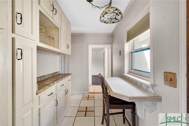 1505 Wilson Rd, Brooklet, GA 30415 - kitchen with crown molding, tile counters, white cabinets, and light tile patterned floors