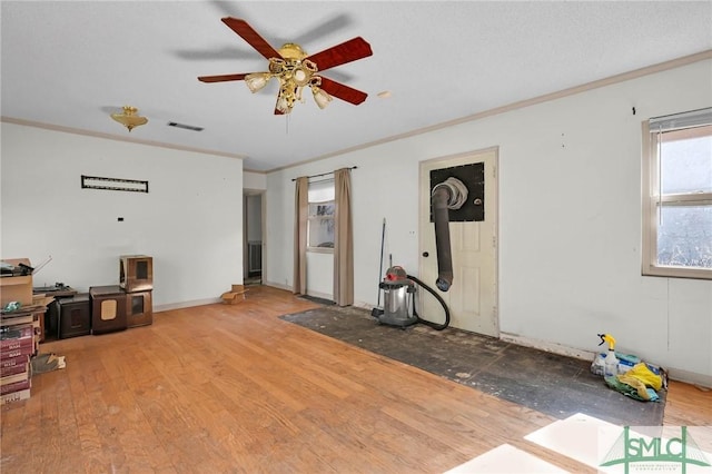 1505 Wilson Rd, Brooklet, GA 30415 - interior space featuring ornamental molding, a ceiling fan, a wood stove, visible vents, and wood finished floors