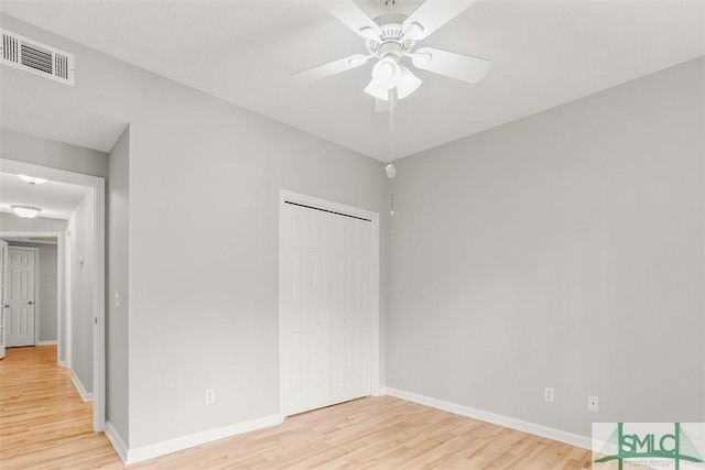 unfurnished bedroom with light wood finished floors, visible vents, a closet, and baseboards