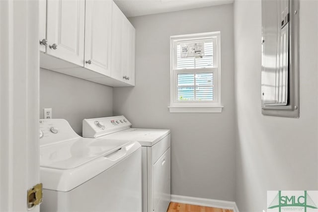 washroom with cabinet space, washing machine and clothes dryer, and baseboards