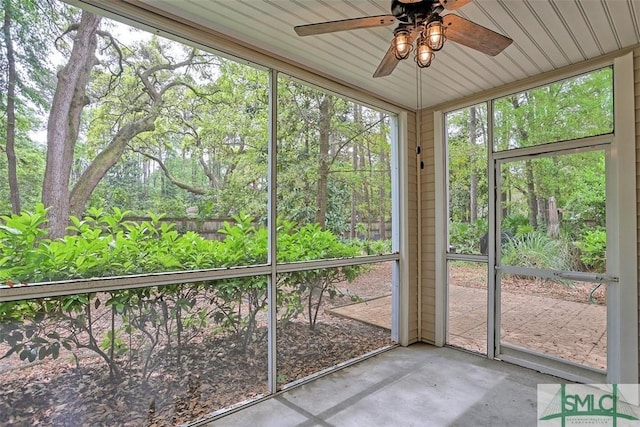 unfurnished sunroom featuring a ceiling fan