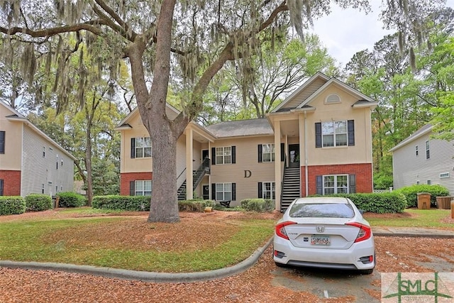 view of front of house featuring brick siding and stairs
