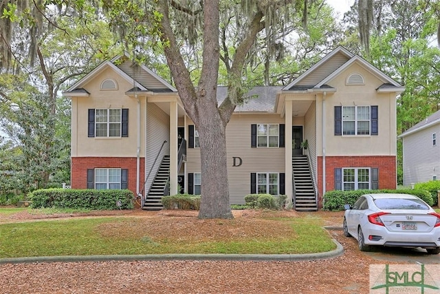view of front of home featuring brick siding and stairs