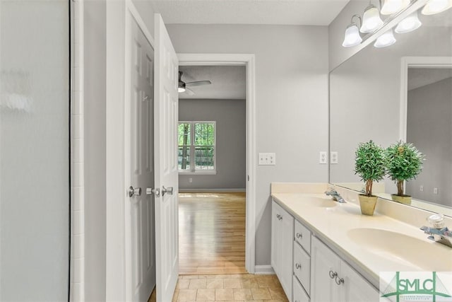 bathroom featuring double vanity, a textured ceiling, a sink, and ceiling fan