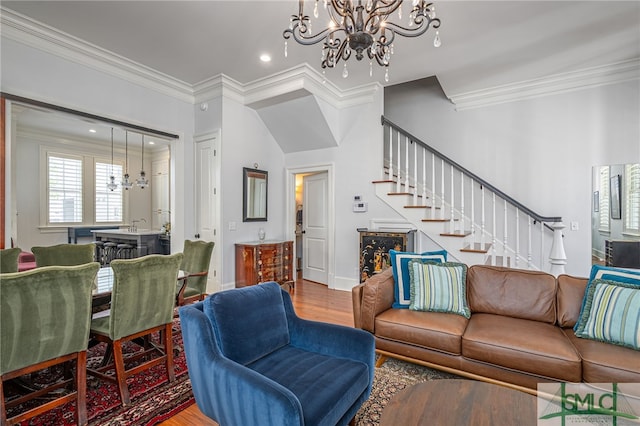 living area with an inviting chandelier, crown molding, recessed lighting, stairway, and wood finished floors