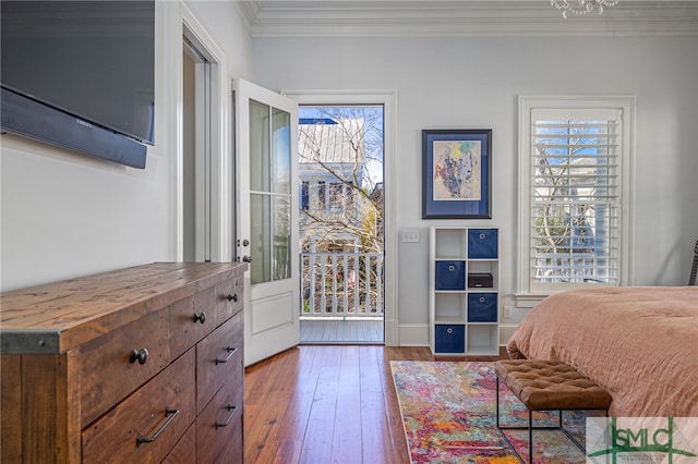 bedroom featuring crown molding, access to exterior, baseboards, and hardwood / wood-style flooring