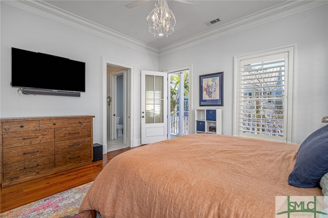 bedroom featuring a chandelier, wood finished floors, ornamental molding, and visible vents