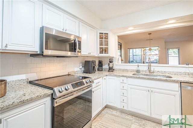 69 Brown Pelican Dr, Savannah, GA 31419 - kitchen with glass insert cabinets, a sink, appliances with stainless steel finishes, white cabinetry, and decorative backsplash