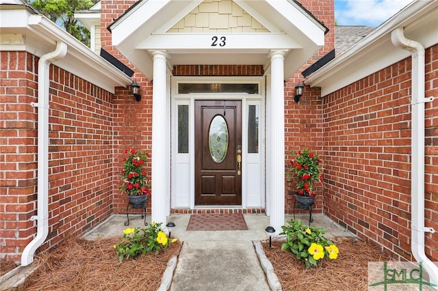 doorway to property featuring brick siding