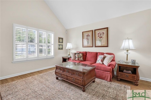 living room with wood finished floors, high vaulted ceiling, and baseboards