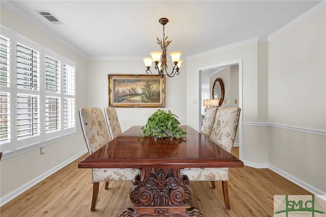 dining space with a notable chandelier, baseboards, light wood-style flooring, crown molding, and visible vents