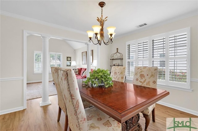 dining area with light wood-type flooring, crown molding, a notable chandelier, and visible vents