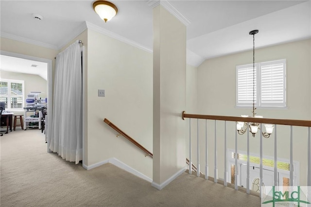corridor with a notable chandelier, baseboards, carpet flooring, an upstairs landing, and crown molding