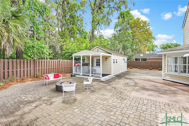 view of patio / terrace with an outbuilding, an outdoor fire pit, and a fenced backyard
