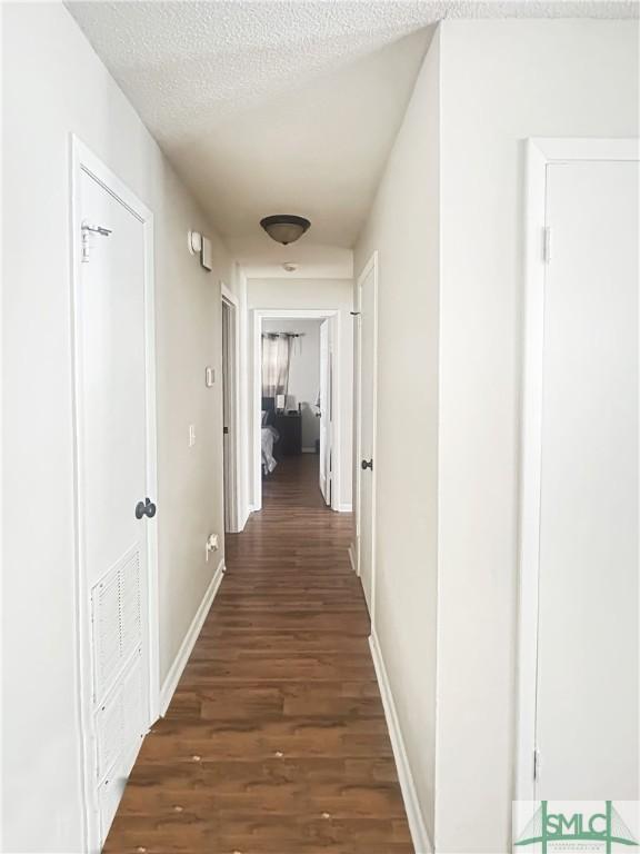 712 Fleming Rd, Hinesville, GA 31313 - hallway with baseboards, wood finished floors, and a textured ceiling