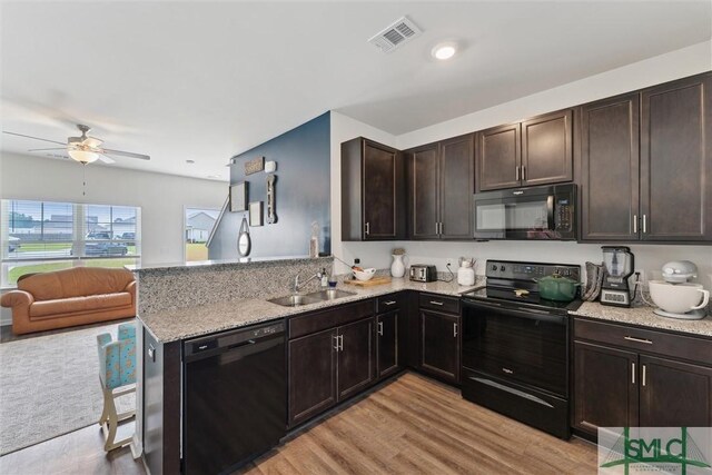 kitchen with visible vents, a sink, a ceiling fan, a peninsula, and black appliances