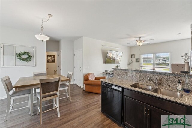 kitchen featuring dishwasher, a sink, ceiling fan, wood finished floors, and light stone countertops