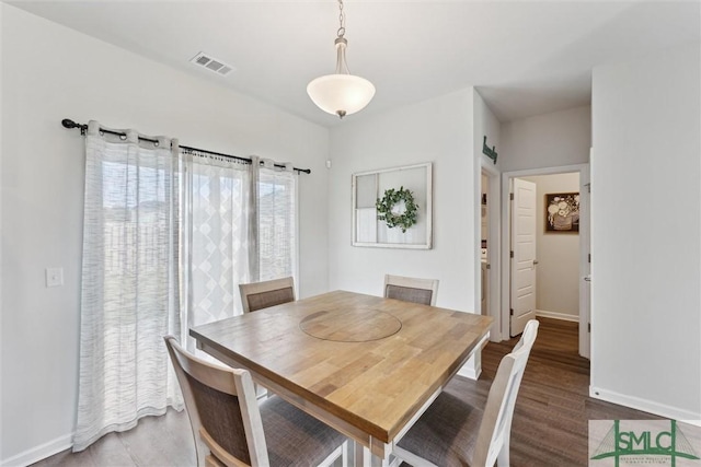 dining room featuring visible vents, baseboards, and wood finished floors