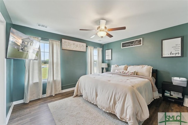 bedroom with wood finished floors, baseboards, multiple windows, and visible vents
