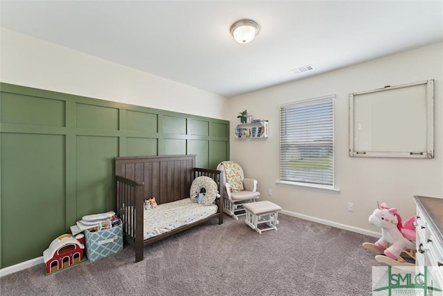 bedroom featuring carpet, visible vents, baseboards, and a nursery area