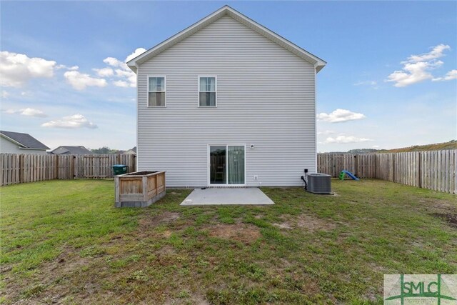 back of property with a yard, a fenced backyard, central AC unit, and a patio