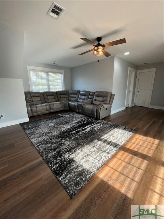 living area featuring visible vents, baseboards, ceiling fan, and wood finished floors