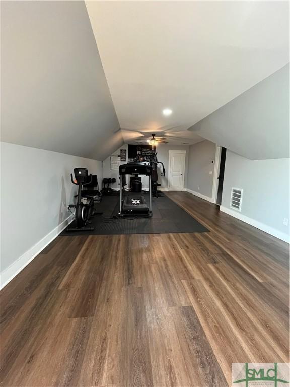 workout room with ceiling fan, visible vents, vaulted ceiling, wood finished floors, and baseboards
