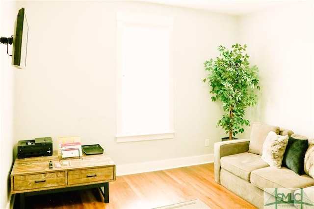 sitting room featuring baseboards and light wood finished floors