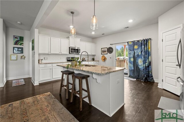 40 Saddlebrush Rd, Ellabell, GA 31308 - kitchen with dark wood-style flooring, white cabinetry, light stone countertops, decorative backsplash, and appliances with stainless steel finishes