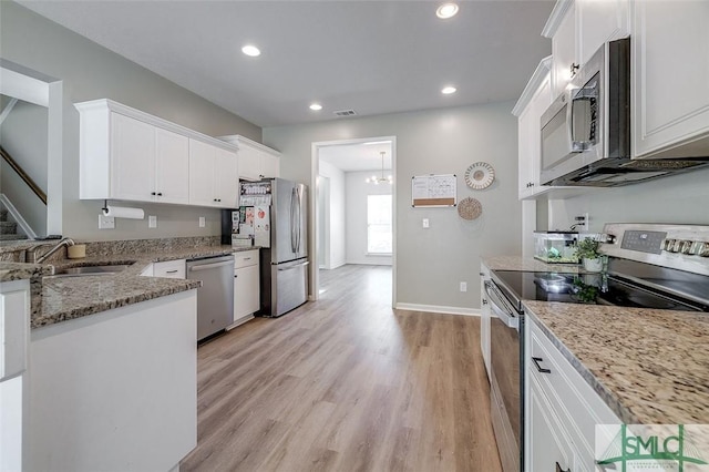 106 Cedar Ridge Dr, Guyton, GA 31312 - kitchen with stainless steel appliances, a sink, light stone countertops, white cabinets, and recessed lighting