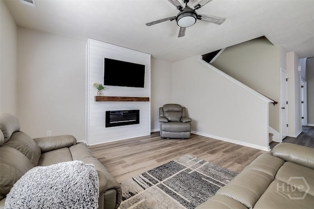 106 Cedar Ridge Dr, Guyton, GA 31312 - living room with wood finished floors, ceiling fan, stairway, a fireplace, and baseboards