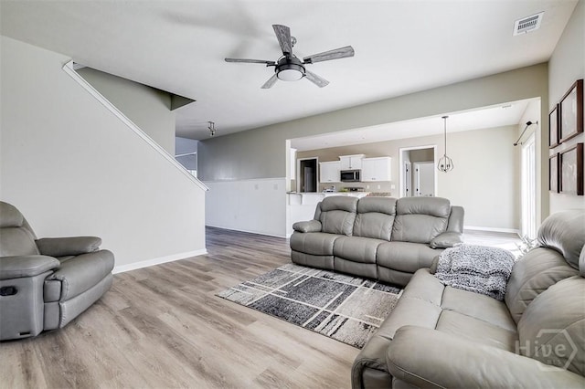 106 Cedar Ridge Dr, Guyton, GA 31312 - living area with light wood finished floors, baseboards, a ceiling fan, and stairway