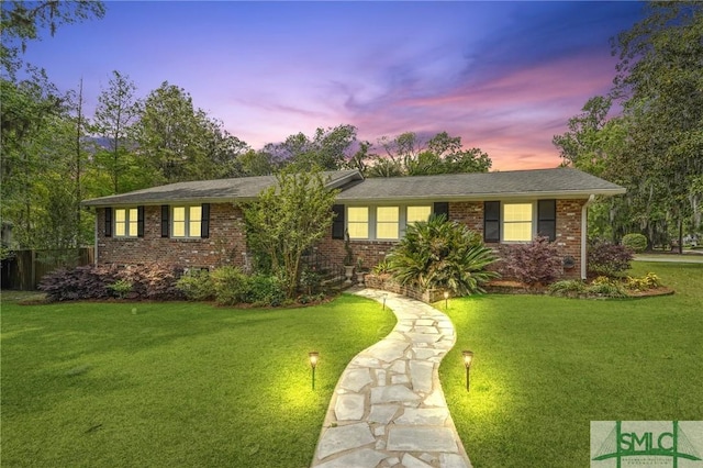 ranch-style house with brick siding and a lawn