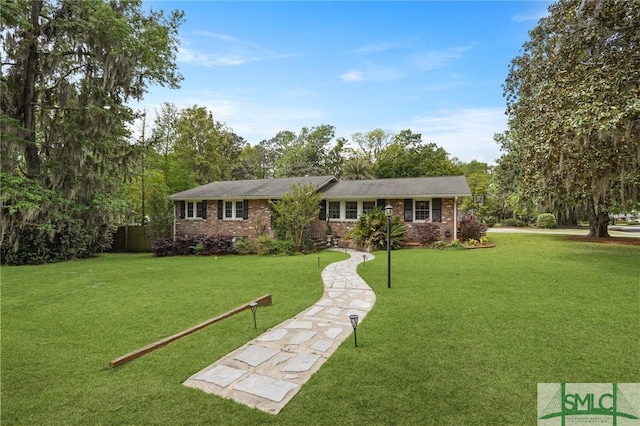 ranch-style house with a front yard and brick siding