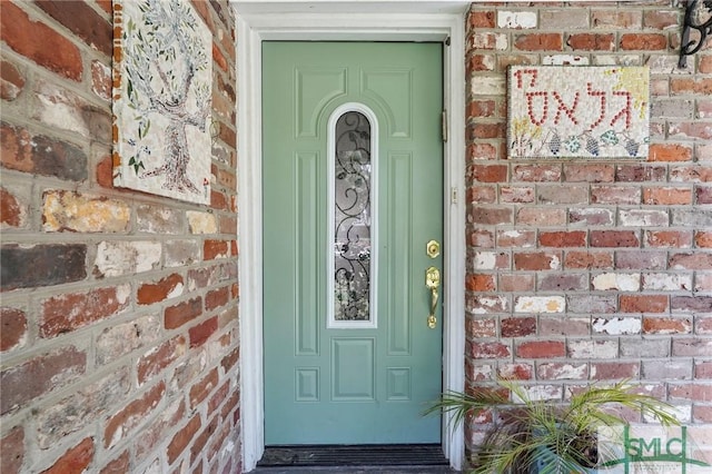 entrance to property featuring brick siding