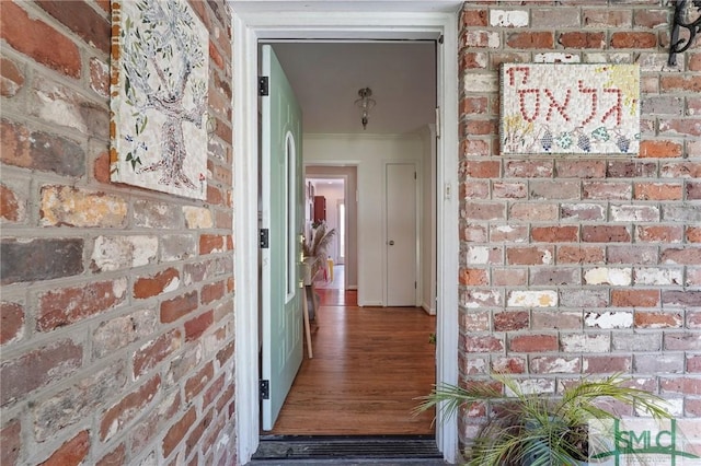 view of exterior entry featuring brick siding
